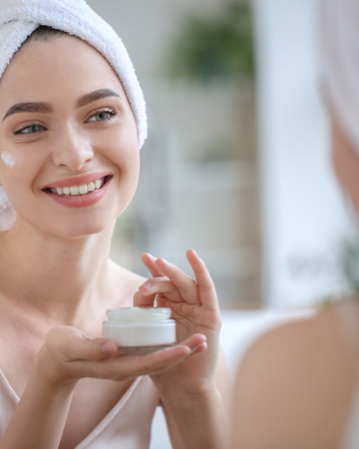 Woman comparing exfoliating acid bottles in a bathroom