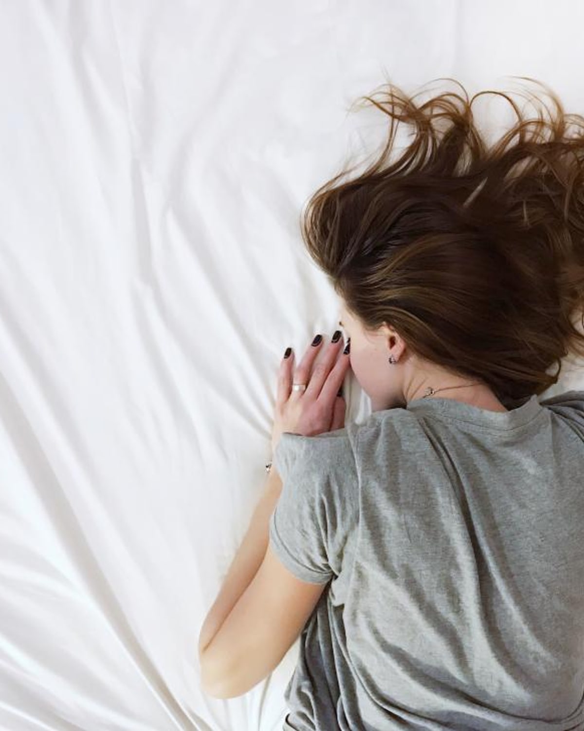 Woman gently checking her scalp and hair in natural light